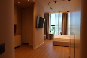 ドゥラスにあるZins Luxury Apartmentsのベッドとテレビがあるホテルの部屋