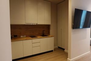 ドゥラスにあるZins Luxury Apartmentsの白いキャビネットとシンクのあるキッチン +103枚の写真