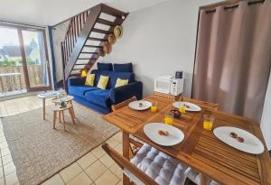 uma sala de estar com uma mesa e um sofá azul em F2 cosy avec balcon em Merville-Franceville-Plage