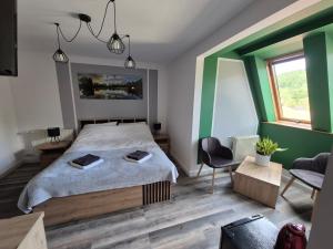 a bedroom with a large bed and a chair at Apartamenty Amadeus & Trattoria Matteo e Raffaello in Stronie Śląskie