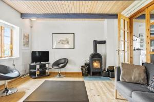 Una sala de estar con un sofá y una estufa de leña. en 4307-Borre-Busenevej-38, en Borre