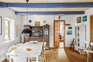 Un comedor con una mesa y sillas blancas. en 4307-Borre-Busenevej-38, en Borre