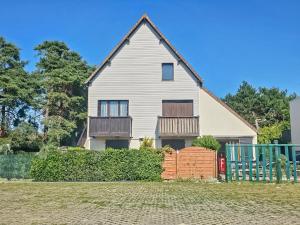 uma casa com uma cerca na frente em F2 cosy avec balcon em Merville-Franceville-Plage