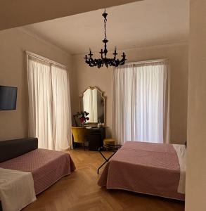 a bedroom with two beds and a chandelier at Stanze di Agatha in Catania