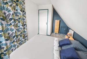 um pequeno quarto no sótão com uma cama e uma janela em F2 cosy avec balcon em Merville-Franceville-Plage