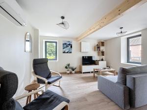 a living room with a couch and a chair at Chez Françoise Campagne Clim Fontfreyde in Saint-Genès-Champanelle