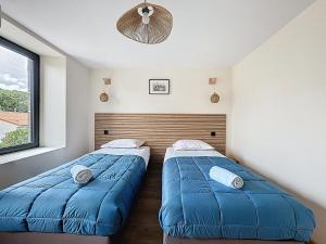 two beds in a bedroom with blue blankets at Chez Françoise Campagne Clim Fontfreyde in Saint-Genès-Champanelle