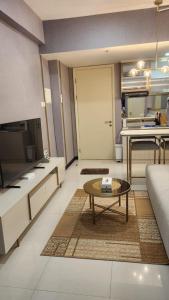 a living room with a couch and a table at Apartment 2BR Amor Pakuwon City Mall Surabaya Indonesia in Surabaya