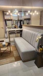 a living room with a couch and a kitchen at Apartment 2BR Amor Pakuwon City Mall Surabaya Indonesia in Surabaya