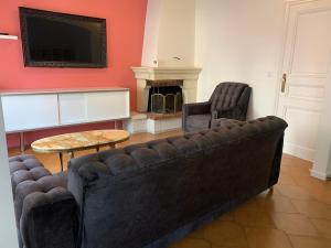 Una sala de estar con un sofá y un televisor. en La glam house, en Saint-Denis