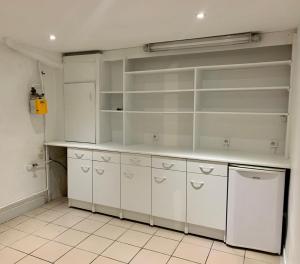 a kitchen with white cabinets and a white refrigerator at La glam house in Saint-Denis