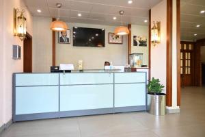 a reception desk in a hospital with a tv on the wall at Grand Hôtel City - Akwa in Douala
