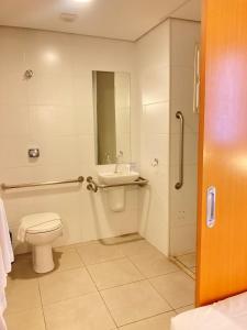 a bathroom with a toilet and a sink at Stop Inn Antonio Carlos in Belo Horizonte