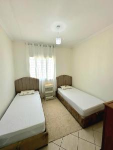 ein Schlafzimmer mit zwei Betten und einem Fenster in der Unterkunft Appartement avec piscine Bouznika in Bouznika
