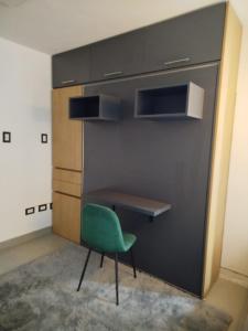 a desk and a green chair in a room at Departamento moderno - Centro de San Luis in San Luis