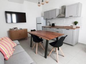 a kitchen with a wooden table and black chairs at Domus Luxi Teulada in Teulada