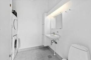 a white bathroom with a toilet and a sink at 1060-Stege-Ulvshalevej-213 in Stege +16 photos