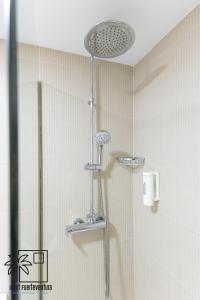 eine Dusche mit Duschkopf in einem Badezimmer in der Unterkunft Palmira Sea View and Lobos Island iRent Fuerteventura in Corralejo