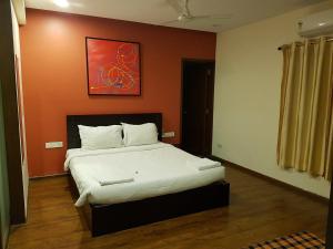 a bedroom with a large bed with an orange wall at ETERNAL WAVE CALANGUTE A Block 204 in Calangute