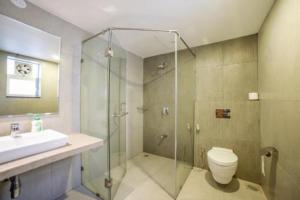 a bathroom with a shower and a toilet and a sink at ETERNAL WAVE CALANGUTE A Block 204 in Calangute
