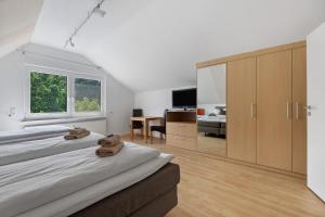 a white bedroom with two beds and a desk at To Hus an´t Water in Wunstorf