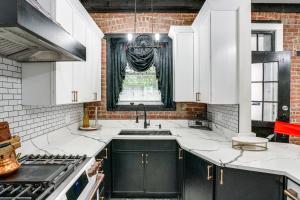 a kitchen with black and white cabinets and a window at Walk to Nott Memorial Studious Retreat Near Eats in Schenectady +16 photos