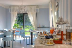 uma sala de jantar com cadeiras azuis e uma mesa com comida em B&B Dodici Lune em Marina dʼAndora