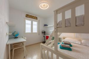 Un dormitorio con una litera y un escritorio. en Casa Pez 2 minutes from the beach, en Tarifa