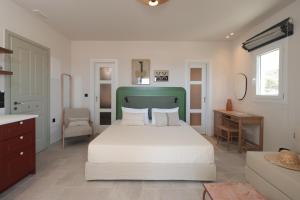 a bedroom with a bed with a green headboard at Phoenicia Nature Naxos in Kastraki +73 photos