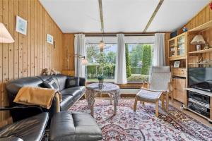 a living room with a leather couch and a table at R845-Rodvig-Maelskifterne-51 in Rødvig
