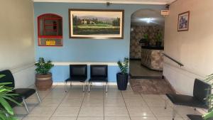 a waiting room with chairs and a painting on the wall at Hotel Santo Antoninho in Goiânia