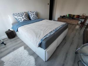 a bedroom with a large bed with blue and white sheets at Sweet Home Inn in Świnoujście