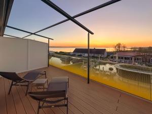 a large balcony with chairs and a view of the ocean at Appartements "Zum Leuchtturm" Hafen Rankwitz Insel Usedom in Rankwitz