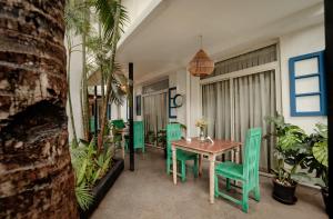 a dining room with a table and green chairs at Oceansuite hotel Goa in Orxel