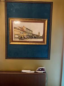 a framed painting of a building on a wall at Classic Love Story in Old Cluj II in Cluj-Napoca
