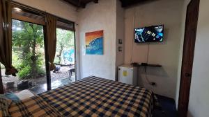 a bedroom with a bed and a tv on the wall at The Blue House Panama in Chame