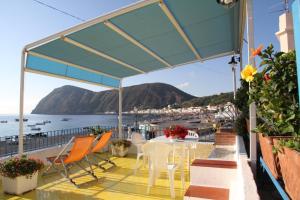 d'une table et de chaises sur un balcon avec vue sur l'océan. dans l'établissement Punta Lena, à Lipari