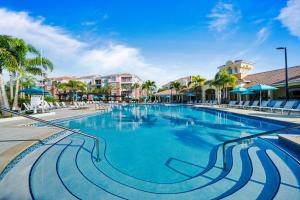 einen Pool in einem Resort mit Palmen und Gebäuden in der Unterkunft Orlando Resort Rentals at Universal Boulevard in Orlando