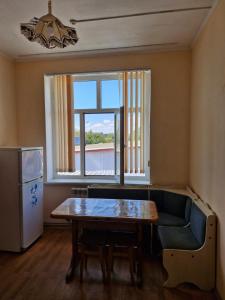a living room with a table and a couch and a window at Арривато in Chornomorsk