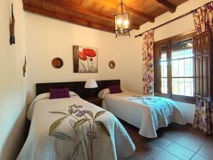 Un dormitorio con dos camas y una ventana. en Villa del Sol, en Frigiliana 22 fotos más
