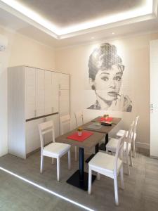 een eetkamer met een tafel en witte stoelen bij Velvet Suite in Rome