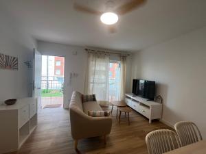 a living room with a couch and a tv at Wind Rose Gandia Beach in Playa de Gandia