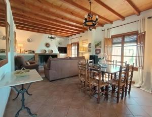 Una cocina y una sala de estar con mesa y sillas. en Villa del Sol, en Frigiliana