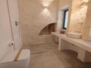 a bathroom with a white toilet and a sink at Palazzo Marconi in Locorotondo