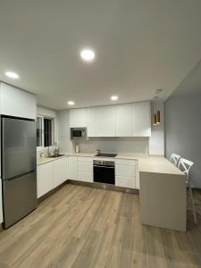 a kitchen with white cabinets and black appliances at Apartamentos Finestrat I-II in Cala de Finestrat