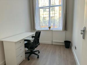 WoolwichにあるStylish 1-bedroom apartmentのデスクと椅子、窓のあるオフィス