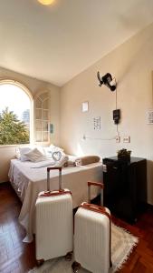 ein Schlafzimmer mit einem Bett und zwei Koffern in der Unterkunft Nuhh Hostel in Belo Horizonte