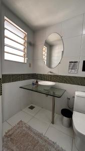 ein Badezimmer mit Waschbecken, Spiegel und Toilette in der Unterkunft Nuhh Hostel in Belo Horizonte