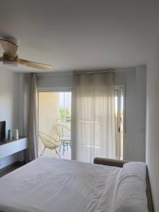 a bedroom with a white bed and a balcony at Apartamentos Finestrat I-II in Cala de Finestrat