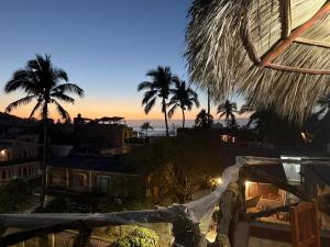 a view of the sunset from a resort with palm trees at Departamento paraíso in Lo de Marcos